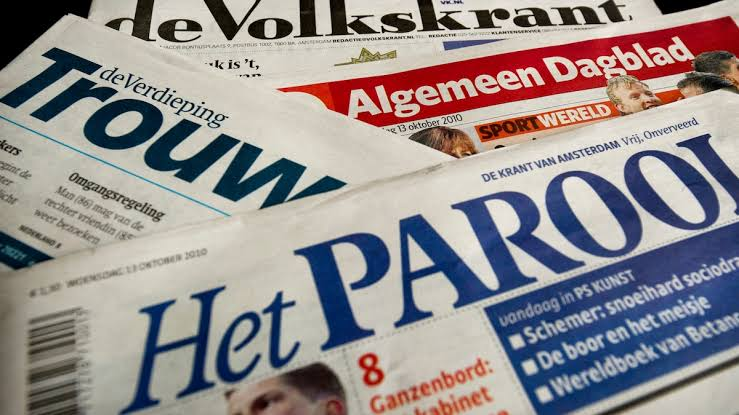 Nederlandse dagbladen, de Volkskrant, Trouw, Algemeen Dagblad en Het Parool, uitgewaaierd op tafel