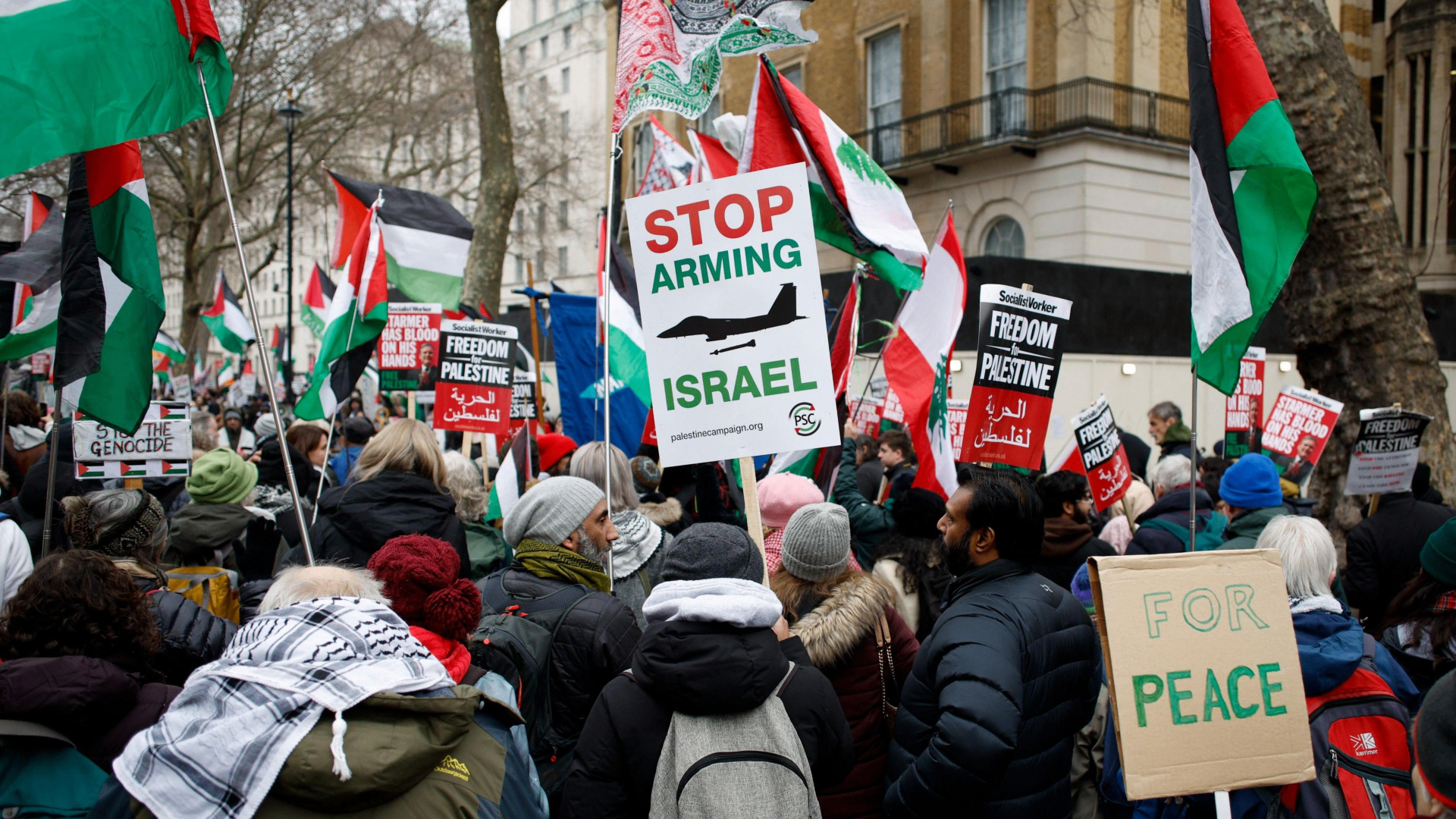 Pro-Palestijnse demonstratie met Palestijnse en Libanese vlaggen en een bord met de tekst 'Stop Arming Israel'