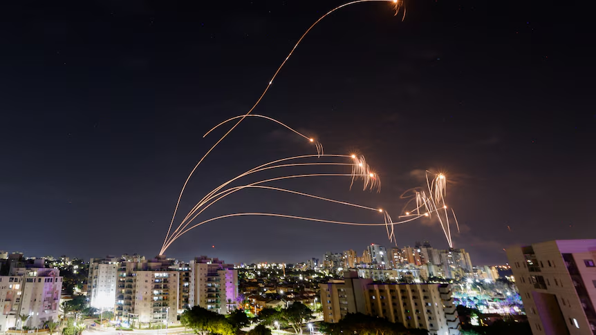 Onderscheppingsraketten trekken oranje sporen door de nachthemel boven Tel Aviv