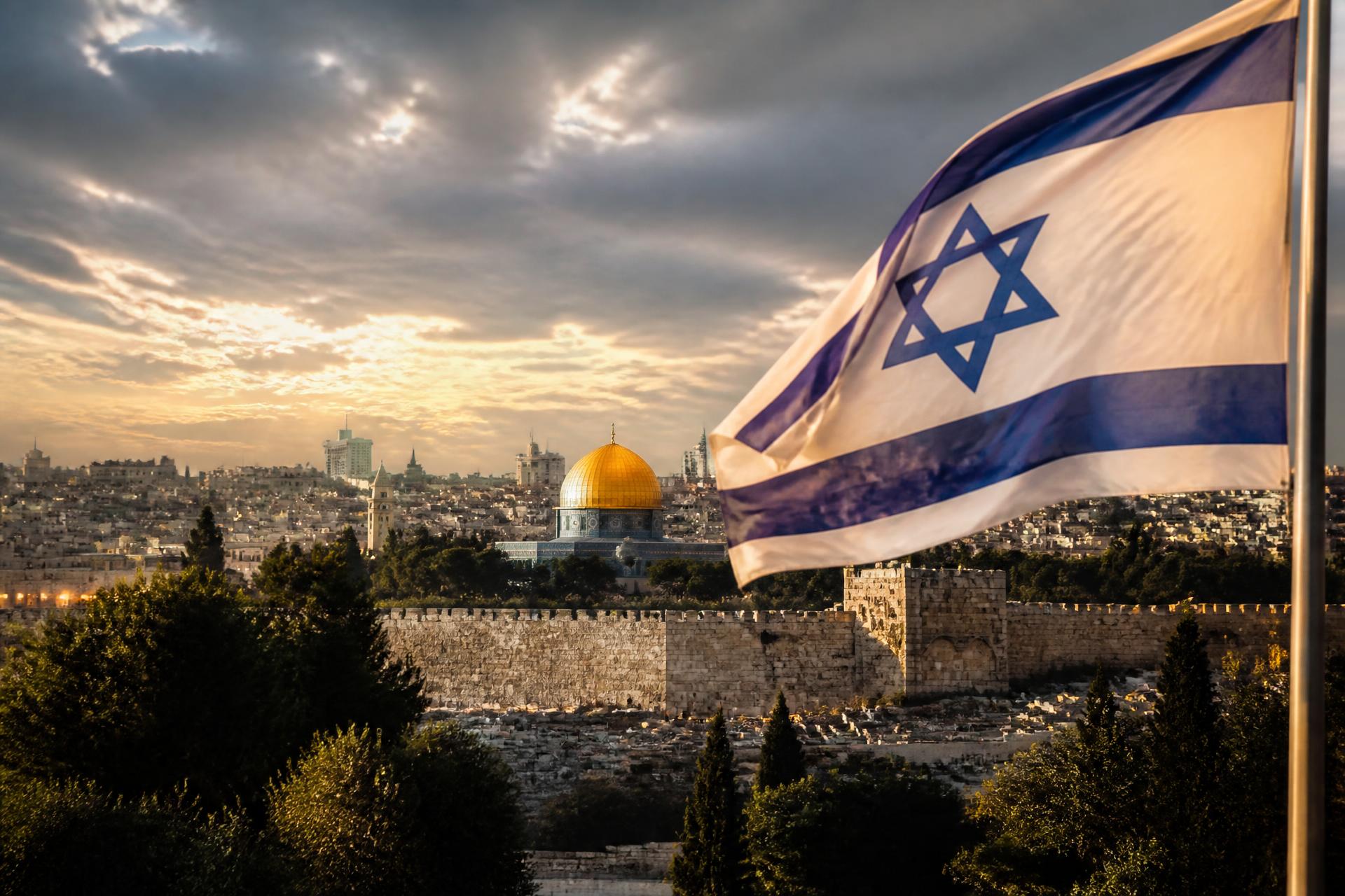 Israëlische vlag wappert boven de oude stad van Jeruzalem met de Rotskoepel bij zonsopgang